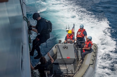 A USS McCampbell sailor disembarks the Royal Brunei Navy ship KDB Darussalam to board a rigid hull inflatable boat during a visit, board, search and seizure training exercise in the South China Sea, Nov. 17, 2016, as part of Cooperation Afloat Readiness and Training 2016. Navy photo by Petty Officer 2nd Class Christian Senyk