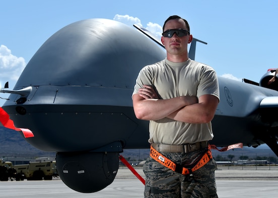 A crew chief assigned to the 432nd Aircraft Maintenance Squadron Tiger Aircraft Maintenance Unit poses for a photo in front of an MQ-9 Reaper Aug. 24, 2016, at Creech Air Force Base, Nevada.  The first MQ-9 launch from Tiger Aircraft Maintenance Unit signals the start of the transition to an all MQ-9 force. (U.S. Air force photo by Airman 1st Class James Thompson)