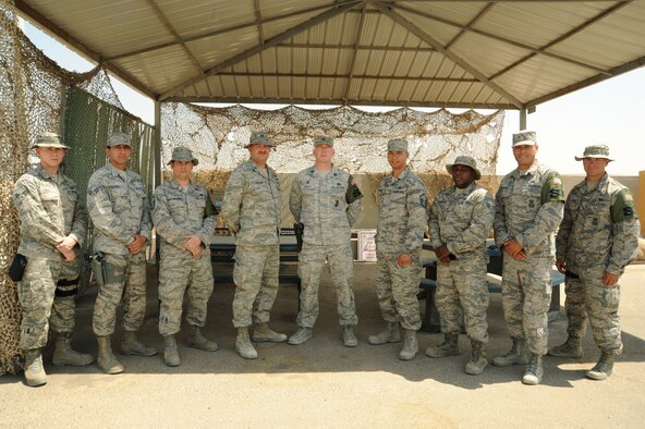 Members of the 387th Air Expeditionary Group force protection flight, civil engineering flight and security forces squadron come together for a group photo at an undisclosed location in Southwest Asia. The units worked together with little to no time off to build a new access road in less than 28 days for the busiest aerial port of debarkation in U.S. Air Forces Central Command. (U.S. Air Force photo/Senior Airman Zachary Kee)