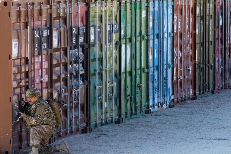 An Army combat medic simulates providing security in a training scenario.
