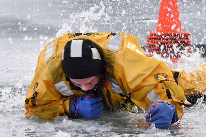 A firefighter with the 127th Civil Engineering Squadron, assigned to the Selfridge Air National Guard Base Fire Department practices using ice awls to extricate himself from hole during an ice rescue training exercise on Lake St. Clair, Harrison Township, Mich. on Jan. 31, 2017.