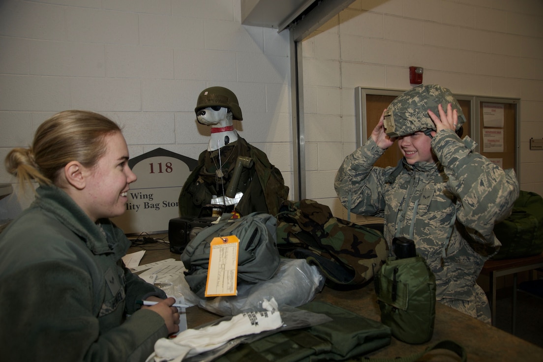 Airman 1st Class Melissa Alotta, 191st Maintenance Squadron, tries on a helmet while receiving her protective chemical warfare gear at Selfridge Air National Guard Base, Mich., Jan. 6, 2018. Issuing the equipment is Airman 1st Class Sarah Henkel, 127th Logistics Readiness Squadron