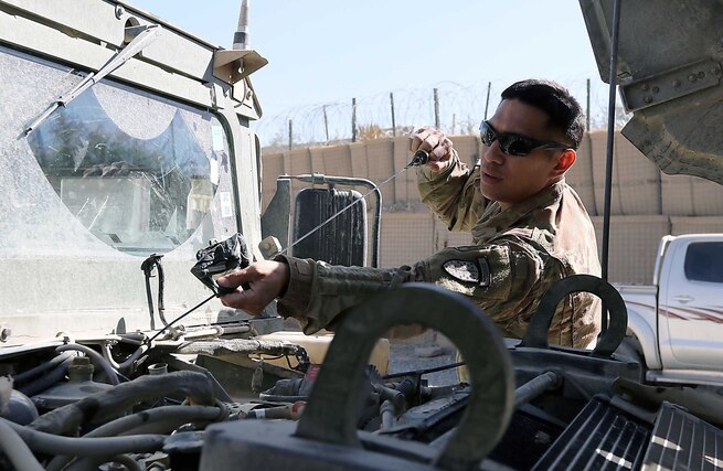 Sgt. Roque Torres, 1st Security Force Assistance Brigade, checks the oil on an Afghan Humvee as part of a training video being produced at Forward Operating Base Lightning, Afghanistan, Oct. 12.
Torres and two other soldiers from the 1st Security Force Assistance Brigade headquarters are training the Afghan National Defense and Security Forces (Army and Police) in an innovative way to conduct preventive maintenance on vehicles.
Using the video recording capability from either a laptop computer or smart phone, these Soldiers ultimately end up with a training video showing Afghans exactly what they need to do to keep vehicles maintained. (Photo by Jon Micheal Connor, Army Public Affairs)