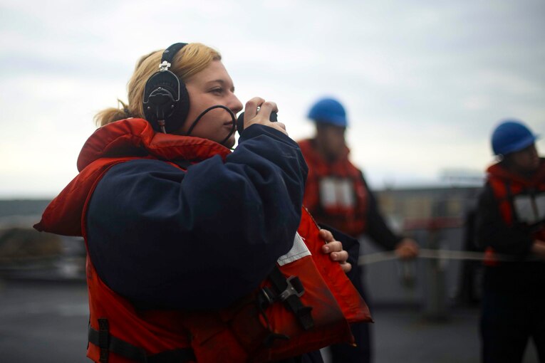 A woman speaks into a telephone.