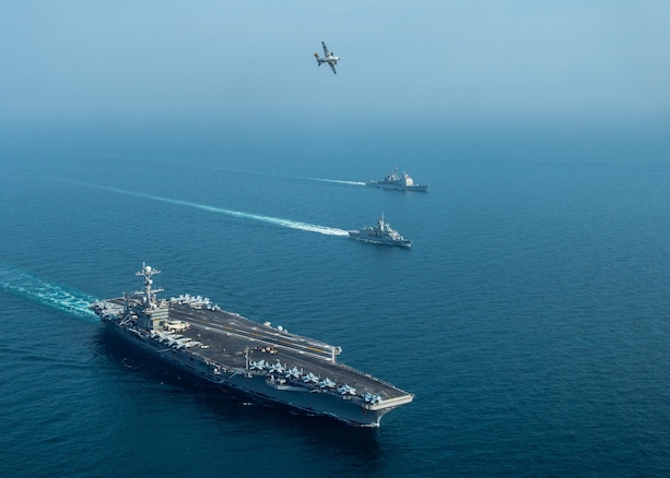 From left to right, the aircraft carrier USS John C. Stennis (CVN 74), the Royal Australian Navy frigate HMAS Ballarat (FFH 155) and the guided-missile cruiser USS Mobile Bay (CG 53) sail in formation as a C-2A Greyhound, assigned to Fleet Logistics Combat Support Squadron (VRC) 30, detachment 4, conducts a flyover in the Arabian Gulf, Jan. 16, 2019, during exercise Intrepid Sentinel. Intrepid Sentinel brings together the John C. Stennis Strike Group, France’s Marine Nationale, United Kingdom’s Royal Navy and the Royal Australian Navy for a multinational exercise designed to enhance war fighting readiness and interoperability between allies and partners. The John C. Stennis Strike Group is deployed to the U.S. 5th Fleet area of operations in support of naval operations to ensure maritime stability and security in the Central Region, connecting the Mediterranean and the Pacific through the western Indian Ocean and three strategic choke points.  (U.S. Navy photo by Mass Communication Specialist 3rd Class Jake Greenberg)