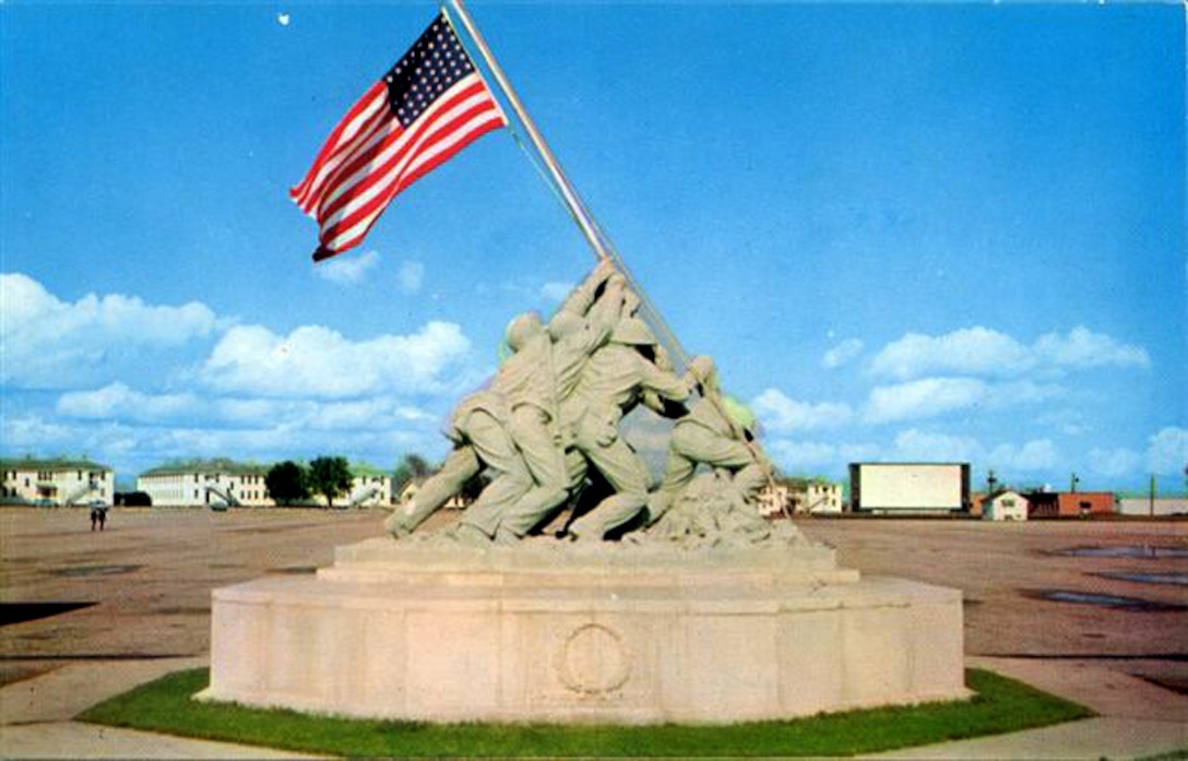 Taken in 1958 by a drill instructor, this photo shows the light green color of the Iwo Jima Memorial, before it was coated with a bronze epoxy paint, and before the parade deck had bleachers and a reviewing stand.