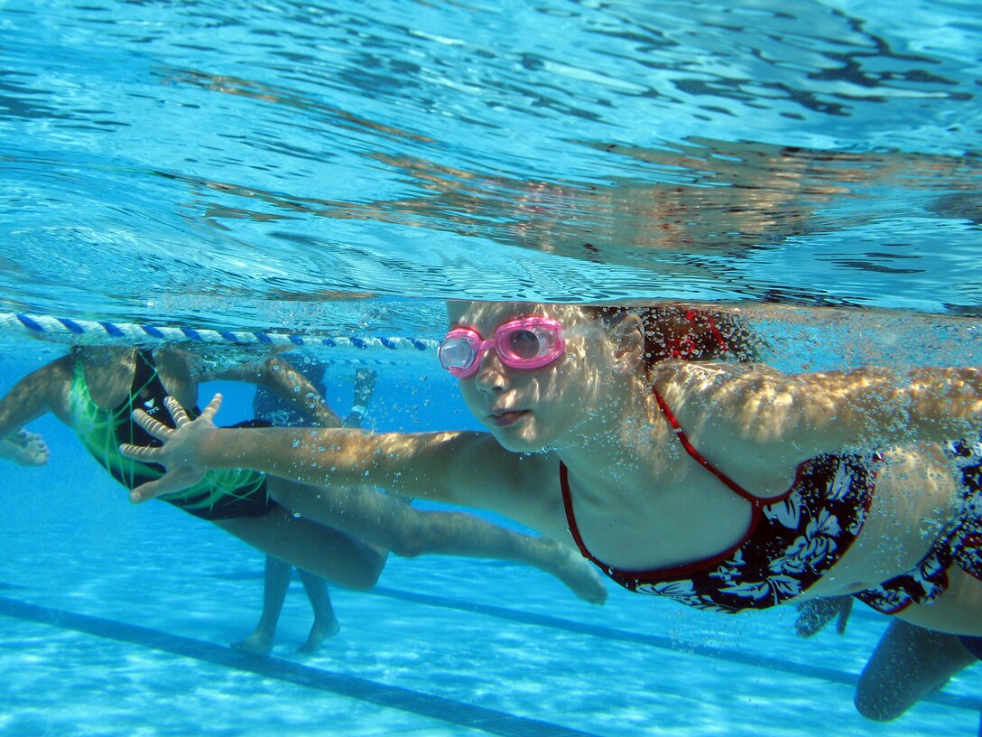 Children speed through the water in the 20-yard freestlye race at the base's Marine Corps Community Services' sixth annual Splashin' Olympics at Camp Pendleton's 13 Area Pool, Aug. 4. The breaststroke and seahorse races are two other events planned for the older age groups.