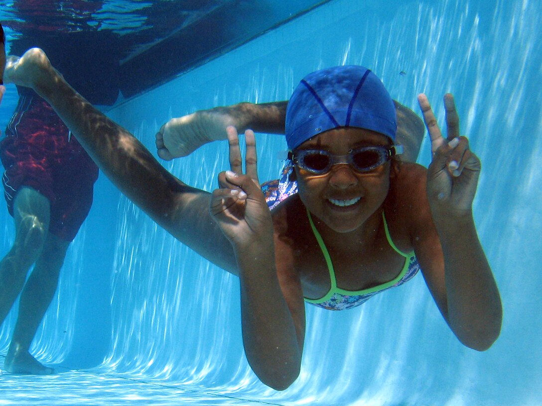 A child smiles underwater for a photograph at the Marine Corps Community Service's sixth annual Splashin' Olympics held at Camp Pendleton's 13 Area Pool, Aug. 4. Children were divided into separate groups during the daylong event.