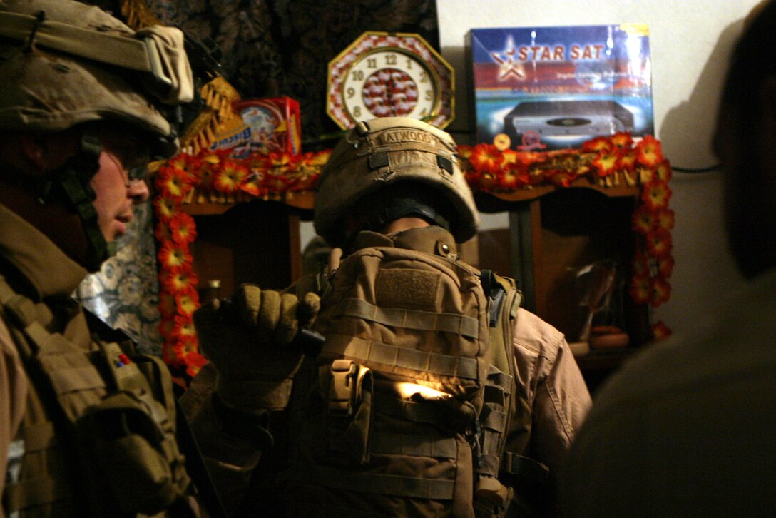 AL RAFTA, Iraq- Cpl. Shawn Atwood, a squad leader with 3rd Platoon, Charlie Company, Task Force 1st Battalion, 4th Marines inspects the belongings of an Iraqi family.  Home searches are done with permission of the homeowner and under his supervision.