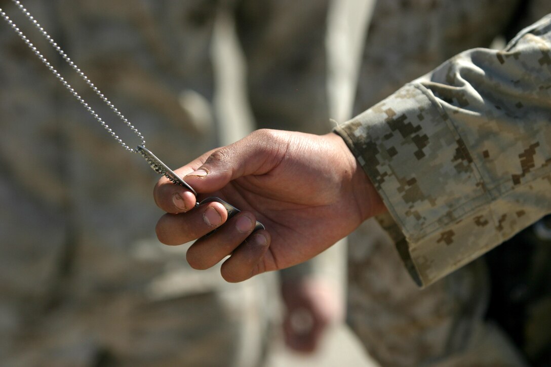 With a gentle rub of identification tags, Marines and sailors of Company A, 1st Battalion, 23rd Marines, Regimental Combat Team 8, pay their final respects to Staff Sgt. Jeremy Smith and Seaman Benjamin Rast May 22. Smith and Rast died while conducting combat operations in Helmand province Afghanistan.::r::::n::::r::::n::::r::::n::