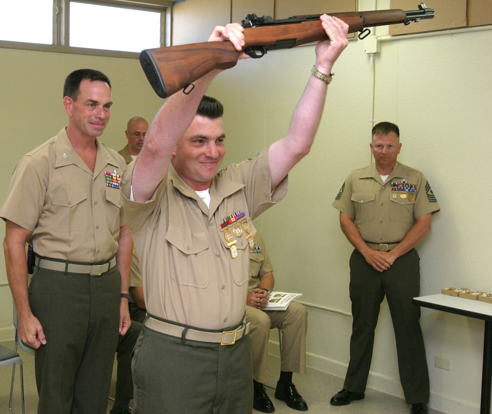 Col. Richard C. Roten (left), deputy commander of MCB Hawaii, stands behind celebrating Troy L. Allenbaugh, "double-distinguished" shooter. Allenbaugh received his fourth M1 Garrand rifle for his performance.