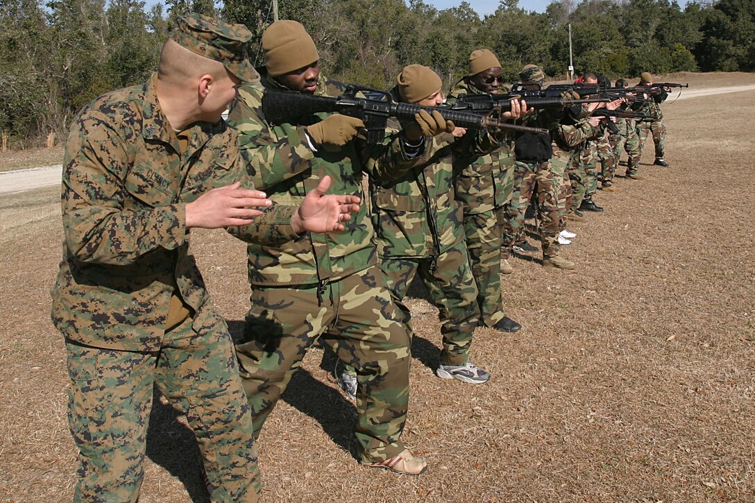 Marine Corps Base Camp Lejeune, N.C. (February 7, 2006)--Sgt. Austin M. Clancy, a 22-year-old weapons sergeant from Salem, Ore., with 2nd Team, Company "A", Foreign Military Training Unit, instructs role-players in firing in the standing position as part of a training exercise.  (Official U. S. Marine Corps photo by Cpl. Ken Melton)