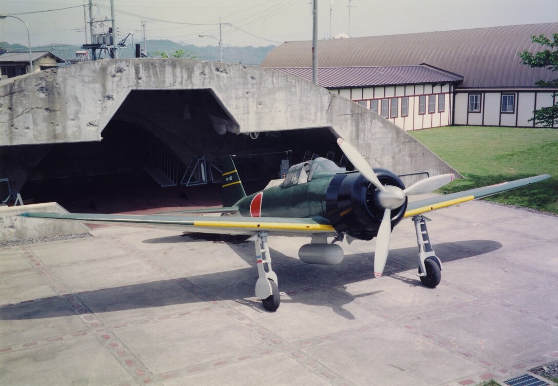 The replica Mitsubishi Type 0 Carrier Fighter sits in front of the Zero Hangar here May 4, 1993. The Zero was a long range fighter aircraft used by the Japanese Imperial Army from 1940 to 1945. The shrapnel-scarred Zero Hangar across the street from the Provost Marshal’s Office here is one of the last few reminders on the air station of the presence the Zero had during the last world war.
