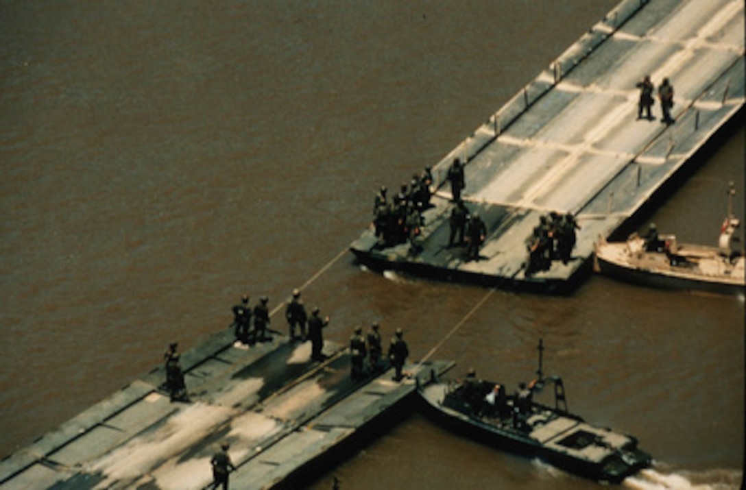 U.S. Army combat engineers join a ribbon float bridge across the Arkansas River during field training near Fort Chaffee, Ark., in July. Ribbon bridges like this will be used by the Army's 1st Armored Division to cross the Sava River between Croatia and Bosnia and Herzegovina. The engineers are part of the NATO Enabling Force of Operation Joint Endeavor. Enabling forces are moving into the Croatia, Bosnia and Herzegovina, and Slovenia theaters of operation to prepare entry points for the main Implementation Force. 