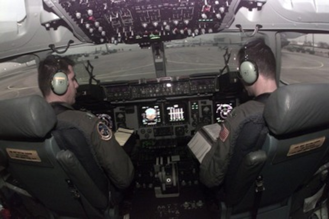 U.S. Air Force Capts. Keith Boone (left) and Ken Norris (right) complete the pre-flight check list for their C-17A Globemaster III at Rhein Main Air Base, Germany, on Dec. 19, 1995. The crew will be flying a cargo of 5 ton trucks to Taszar Air Field near Kaposvar, Hungary, to support the NATO Enabling Force of Operation Joint Endeavor. Enabling forces are moving into the Croatia, Bosnia and Herzegovina, and Slovenia theaters of operation to prepare entry points for the main Implementation Force. Boone and Norris are attached to the 14th Airlift Squadron, 437th Airlift Wing, Charleston Air Force Base, S.C. 