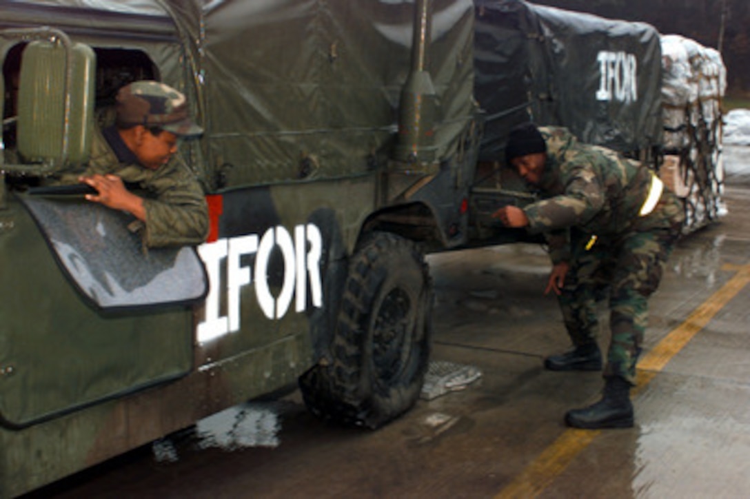 U. S. Air Force Staff Sgt. Richard Williams guides a driver as he backs his Humvee onto a scale in the marshaling yard at Ramstein Air Base, Germany, on Dec. 21, 1995. Equipment from all over the world is arriving at Ramstein to be staged for deployment to Bosnia and Herzegovina where it will be used by the NATO Implementation Force (IFOR). Williams needs to be sure of the weight of the vehicle so that he can assign it a chalk number for a flight to Bosnia and Herzegovina. Williams is in charge of marshaling for the 86th Transportation Squadron's at Ramstein. 