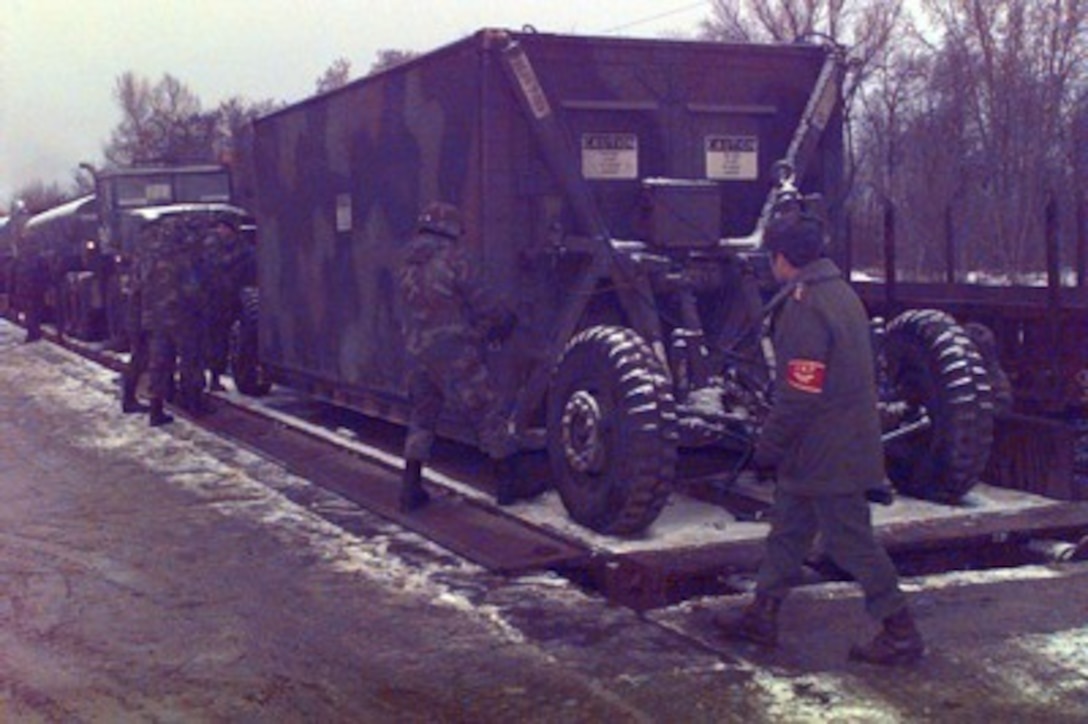 A Hungarian soldier assists U.S. Army soldiers as they unload equipment from a railroad car at Taszar Air Base near Kaposvar, Hungary, on Dec. 22, 1995, during Operation Joint Endeavor. The equipment is being unloaded by Reception, Staging, Onward movement and Integration or RSOI forces are working at theater of operations entry points to support the NATO Implementation Force (IFOR) in Bosnia and Herzegovina. The U.S. soldiers are attached to the 563rd Ordnance Company, Miezow, Germany. 