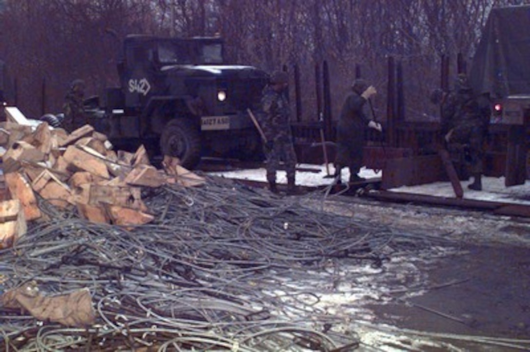 U.S. Army soldiers un-brace and un-block equipment as they unload a railroad car at Taszar Air Base near Kaposvar, Hungary, on Dec. 22, 1995, during Operation Joint Endeavor. The equipment is being unloaded by Reception, Staging, Onward movement and Integration or RSOI forces are working at theater of operations entry points to support the NATO Implementation Force (IFOR) in Bosnia and Herzegovina. The U.S. soldiers are attached to the 563rd Ordnance Company, Miezow, Germany. 