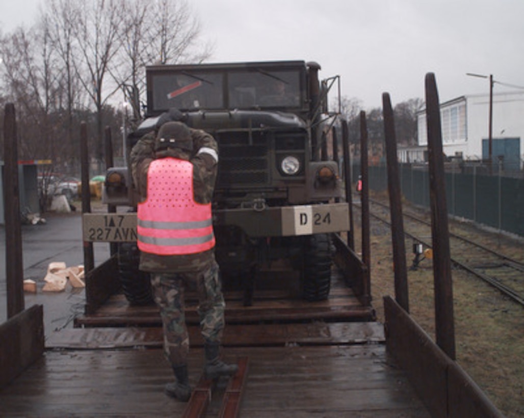 U. S. Army Staff Sgt. Henry Larson guides a 5-ton truck onto a railroad car at Hanau, Germany, on Dec. 22, 1995, for deployment to NATO's Operation Joint Endeavor. Military equipment from all over the world is being deployed to Bosnia and Herzegovina where it will be used by the NATO Implementation Force (IFOR). Larson is attached to Bravo Company, 578th Air Defense Artillery Battalion. 