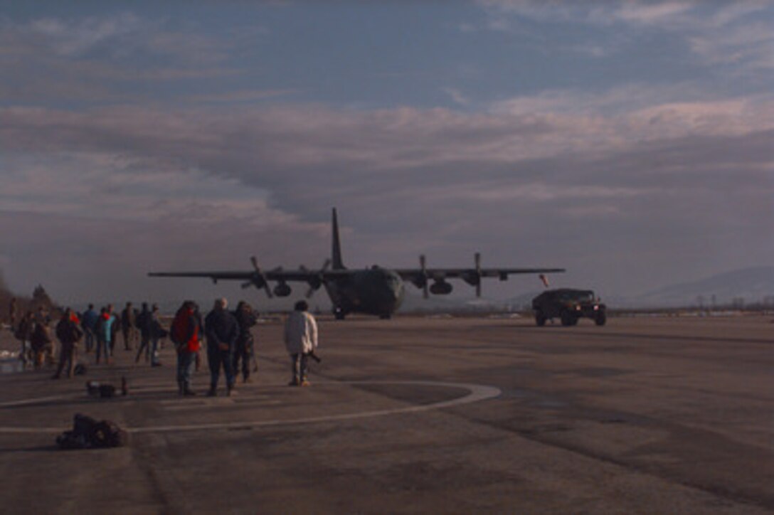A U.S. Air Force C-130 Hercules taxis past news media on the ramp after landing at Tuzla Air Base, Bosnia and Herzegovina, on Dec. 22, 1995. The Hercules is delivering cargo and passengers in support of the NATO's Operation Joint Endeavor. The cargo and soldiers are part of the NATO Implementation Force (IFOR) in Bosnia and Herzegovina. 