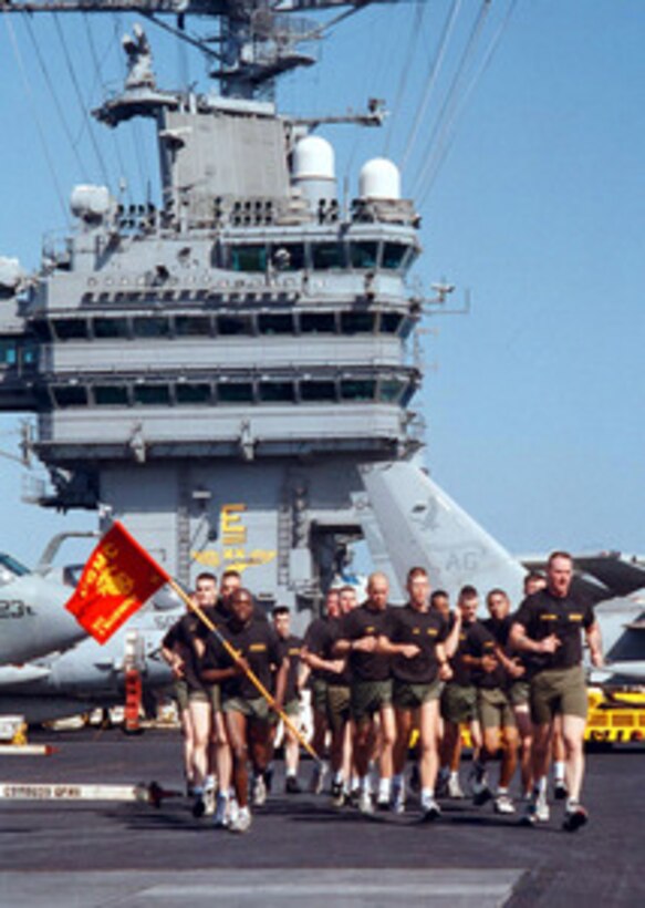 The USS George Washington (CVN 73) Marine Detachment runs in formation across the flight deck of the aircraft carrier during a lull in flight operations as part of their physical fitness regimen on March 30, 1996. The George Washington and its battle group are operating in the Arabian Gulf where they are conducting air patrols in support of Operation Southern Watch. Southern Watch is the U.S. and coalition enforcement of the no-fly-zone over Southern Iraq. 