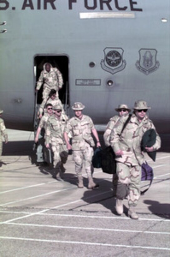 U.S. Air Force personnel from the 1st Fighter Wing, Langley Air Force Base, Va., disembark from a C-141B Starlifter at a Jordanian Air Force Base on March 30, 1996. The aircraft brought personnel, cargo, and support equipment for a U.S. Air Force Air Power Expeditionary Force which will operate out of Jordan. The Expeditionary Force will provide additional land-based air forces to augment regional assets. The deployment will also give the Air Force an opportunity to work and train with coalition partners in the region. The deployment should be completed near the end of June 1996. 