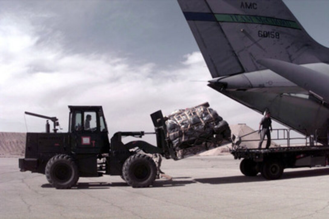 U.S. Air Force personnel from the 621st Aerial Port Squadron use a fork lift to unload cargo from a C-141B Starlifter at a Jordanian Air Force Base on March 30, 1996. The aircraft brought personnel, cargo, and support equipment for a U.S. Air Force Air Power Expeditionary Force which will operate out of Jordan. The Expeditionary Force will provide additional land-based air forces to augment regional assets. The deployment will also give the Air Force an opportunity to work and train with coalition partners in the region. The deployment should be completed near the end of June 1996. The 621st is from McGuire Air Force Base, N.J. 
