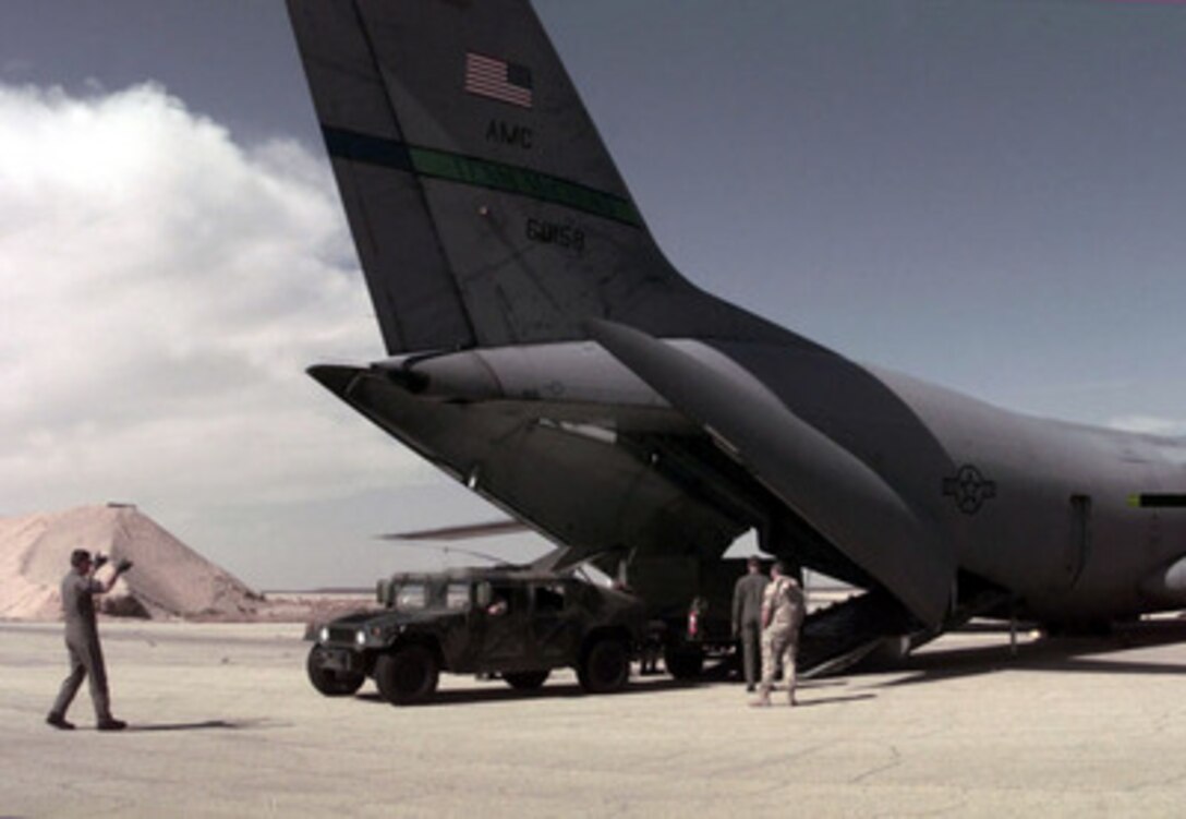 A member of the 621st Aerial Port Squadron directs the driver of a Humvee coming out off a C-141B Starlifter at a Jordanian Air Force Base on March 30, 1996. The aircraft brought personnel, cargo, and support equipment for a U.S. Air Force Air Power Expeditionary Force which will operate out of Jordan. The Expeditionary Force will provide additional land-based air forces to augment regional assets. The deployment will also give the Air Force an opportunity to work and train with coalition partners in the region. The deployment should be completed near the end of June 1996. The 621st is from McGuire Air Force Base, N.J. 
