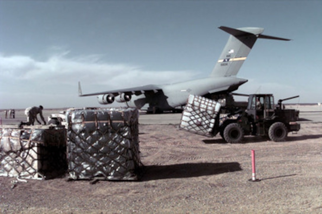 U.S. Air Force personnel from the 621st Aerial Port Squadron use a fork lift to unload cargo from a C-17 Globemaster III at a Jordanian Air Force Base on March 30, 1996. The aircraft brought personnel, cargo, and support equipment for a U.S. Air Force Air Power Expeditionary Force which will operate out of Jordan. The Expeditionary Force will provide additional land-based air forces to augment regional assets. The deployment will also give the Air Force an opportunity to work and train with coalition partners in the region. The deployment should be completed near the end of June 1996. The 621st is from McGuire Air Force Base, N.J. The aircraft is assigned to the 14th Airlift Squadron, Charleston Air Force Base, S.C. 