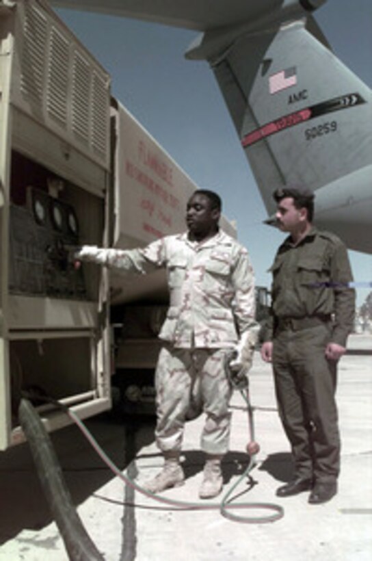 U.S. Air Force Senior Airman Michael E. Edwards (left) of the 1st Supply Squadron, Langley Air Force Base, Va., refuels a C-141B Starlifter as Jordanian Air Force 1st Sgt. Ihal Z. Alzouby (right) watches the procedure at a Jordanian Air Force Base on March 30, 1996. The aircraft brought personnel, cargo, and support equipment for a U.S. Air Force Air Power Expeditionary Force which will operate out of Jordan. The Expeditionary Force will provide additional land-based air forces to augment regional assets. The deployment will also give the Air Force an opportunity to work and train with coalition partners in the region. The deployment should be completed near the end of June 1996. Edwards, a Newark, N.J. native, is a fuels specialist. 1st Sgt. Ihal Z. Alzouby is a supply specialist with the Jordanian Air Force. 
