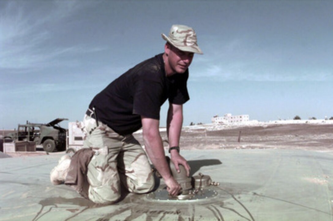 Tech. Sgt. Donnie J. Edwards, a Utilities Foreman assigned to the 1st Civil Engineering Squadron, attaches a 90 degree Cam Lock to a 20,000 gallon water bladder for a tent city being built by U.S. Air Force civil engineers at a Jordanian Air Base on April 4, 1996. Engineering squadrons are building a small tent city to support a U.S. Air Force Air Power Expeditionary Force which will operate out of Jordan. The Expeditionary Force will provide additional land-based air forces to augment regional assets. The deployment will also give the Air Force an opportunity to work and train with coalition partners in the region. The deployment should be completed near the end of June 1996. The 1st Civil is deployed from Langley Air Force Base, Va., and is constructing the water system. Edwards is a Baxter, W. Va., native. 