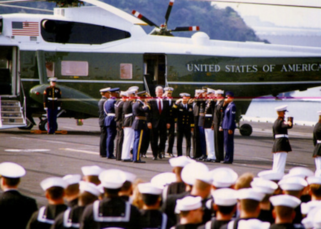 President Bill Clinton is piped aboard as he goes through the sideboys on the U.S. Navy aircraft carrier USS Independence (CV 62) at her homeport of Yokosuka, Japan, on Wednesday, April 17, 1996. The President took time out from his state visit to Japan to meet with the crew of the carrier and to thank them for their role in representing U.S. interests during their deployment off the coast of Taiwan. 