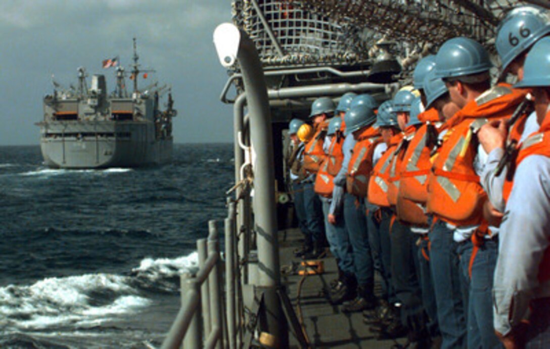 Crew members of the USS Thomas Gates (CG 51) stand by at their replenishment station as the ship makes its approach on the USS Kalamazoo (AOR 6) for underway refueling off the coast of Florida on March 26, 1996. The ships are part of an armada from seven NATO nations participating in Exercise Unified Spirit '96. The combined exercise is designed to improve the readiness and effectiveness of NATO forces in the areas of command communication, embargo enforcement, freedom of navigation and protection and coordination with mine warfare forces. 