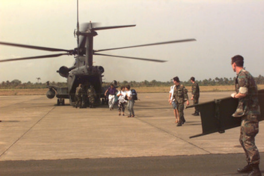 A U.S. Air Force Para-rescueman waits with a stretcher as U.S. citizens and others evacuated from Monrovia, Liberia, exit the tail of a U.S. Air Force MH-53 Pavelow helicopter at the airport in Freetown, Sierra Leone on April 11, 1996. U.S military forces are evacuating U.S. citizens and citizens of 72 other countries from Liberia at the request of the U.S. ambassador to Liberia. The MH-53 Pavelow and its crew are deployed from the 352nd Special Operations Group, Mildenhall, United Kingdom, to Freetown in support of Operation Assured Response. 