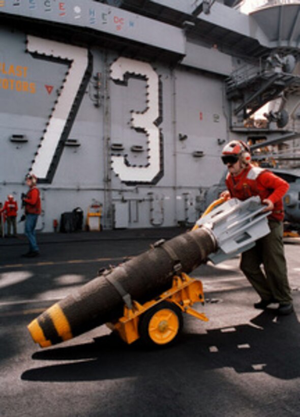 Petty Officer 2nd Class Stanford Stenson carts a pair of bombs across the flight deck of the aircraft carrier USS George Washington (CVN 73) on April 11, 1996. The bombs will be loaded on a F/A-18C Hornet which is being prepared to launch for a training mission over a bombing range in Kuwait. The George Washington and its battle group are operating in the Arabian Gulf where they are conducting air patrols in support of Operation Southern Watch. Southern Watch is the U.S. and coalition enforcement of the no-fly-zone over Southern Iraq. Stenson, a Custer, S.D., native, is a Navy Aviation Ordnanceman. 