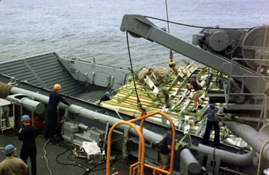 A section of TWA Flight 800's forward fuselage section is transferred from the Navy's salvage and recovery ship USS Grapple (ARS 53) to a utility craft. From there, the fuselage section will be transferred ashore. 