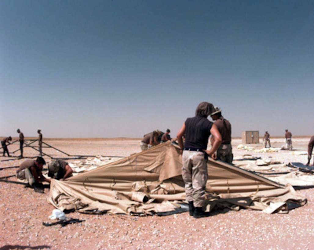 U.S. Air Force engineers get ready to raise the roof of a tent they are erecting at Prince Sultan Air Base at Al Kharj, Saudi Arabia, on August 9, 1996. The tent is one of 500 they will put up to house U.S. personnel conducting Operation Southern Watch. Nearly 4,000 personnel, aircraft, and equipment are being moved from bases in Dhahran and Riyadh to the remote desert air base to reduce their vulnerability to terrorist attack. Southern Watch is the U.S. and coalition enforcement of the no-fly-zone over Southern Iraq. The engineers are from the 823rd Red Horse Squadron, Hurlburt Field, Fla., and the 49th Material Maintenance Group, Holloman Air Force Base, N. M. 