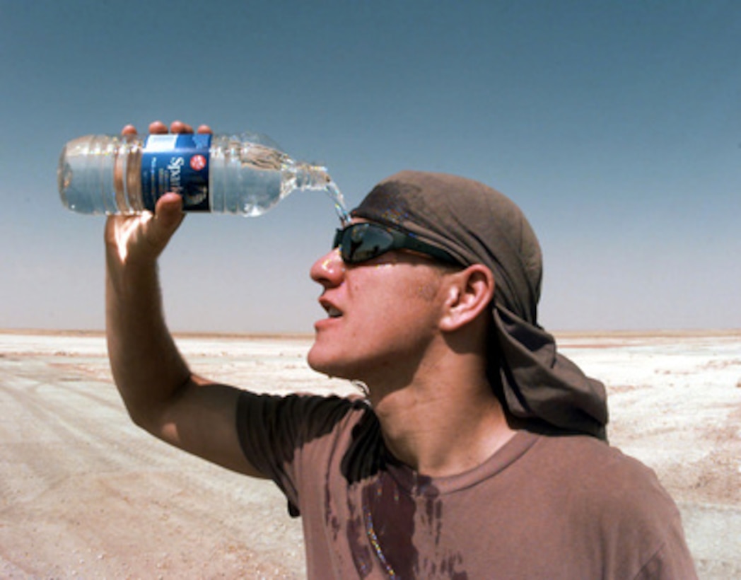 Airman 1st Class Brad N. Boudreaux tries to beat the heat of the Saudi Arabian desert by pouring water over his face during a break from erecting a tent at Prince Sultan Air Base at Al Kharj, Saudi Arabia, on August 9, 1996. The tent is one of 500 that Air Force engineers will put up to house U.S. personnel conducting Operation Southern Watch. Nearly 4,000 personnel, aircraft, and equipment are being moved from bases in Dhahran and Riyadh to the remote desert air base to reduce their vulnerability to terrorist attack. Southern Watch is the U.S. and coalition enforcement of the no-fly-zone over Southern Iraq. Boudreaux is deployed with the 823rd Red Horse Squadron, Hurlburt Field, Fla. 