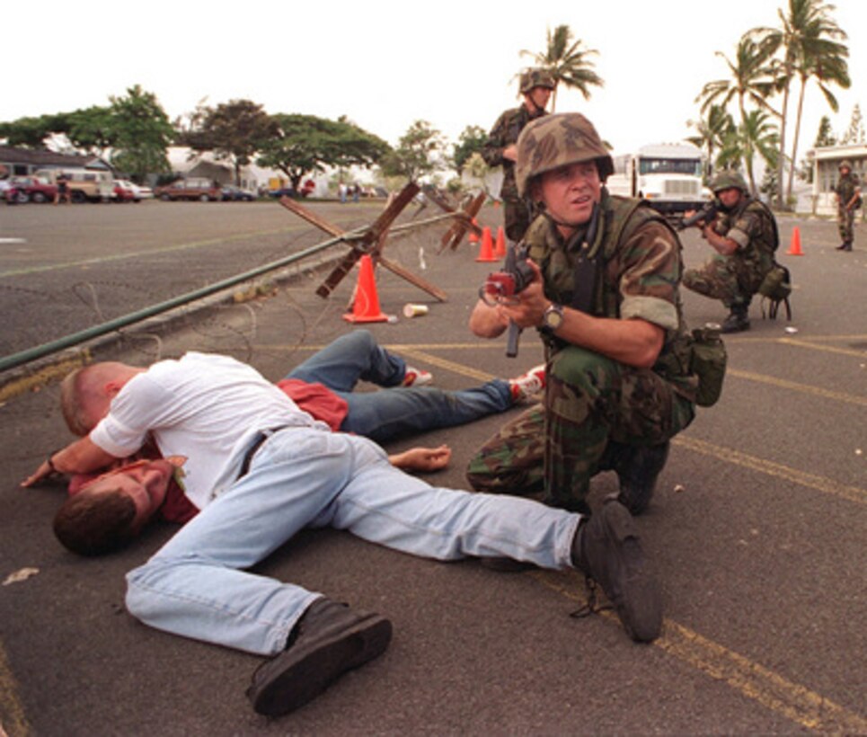 Navy Hospital Corpsman Eric Carver watches over two simulated wounded civilians seeking asylum in a fictitious American embassy while being fired upon during a simulated Noncombatant Evacuation Operation on June 11, 1996, at Kaneohe Bay Marine Corps Station, Hawaii, as part of exercise RIMPAC '96. More than 44 ships, 200 aircraft and 30,000 soldiers, sailors, Marines, airmen and Coast Guardsmen are involved in the exercise. The purpose of RIMPAC '96 is to improve coordination and interoperability of combined and joint forces in maritime tactical and theater operations. Australia, Canada, Chile, Japan, the Republic of Korea and the U.S. are participating in the exercise. 
