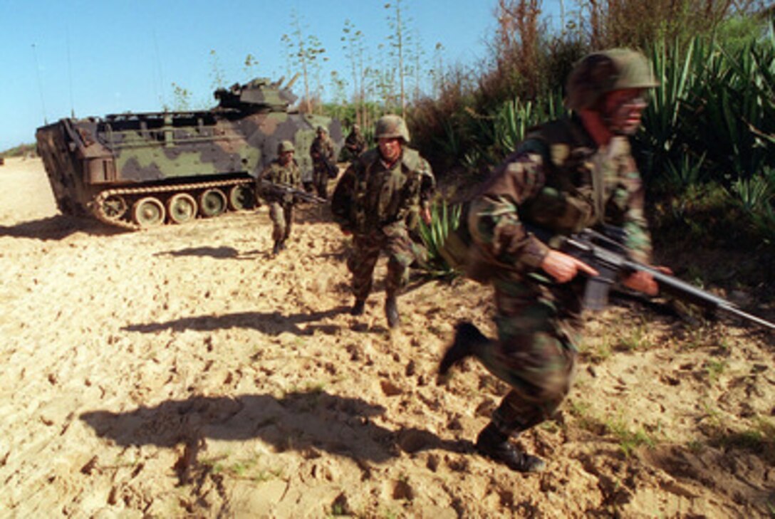 U.S. Marines race through the sand of Kauai, Hawaii, to establish a strategic position following an amphibious landing in Amphibious Assault Vehicles on June 15, 1996, during RIMPAC '96. The amphibious assault at Pacific Missile Range Facility, Barking Sands, Hawaii, is being conducted by 11th Marine Expeditionary Unit, Camp Pendleton, Calif., and involves Navy and Marine air, ground and sea forces for training as a combined amphibious assault force. More than 44 ships, 200 aircraft and 30,000 soldiers, sailors, Marines, airmen and Coast Guardsmen are involved in the exercise. The purpose of RIMPAC '96 is to improve coordination and interoperability of combined and joint forces in maritime tactical and theater operations. Australia, Canada, Chile, Japan, the Republic of Korea and the U.S. are participating in the exercise. 
