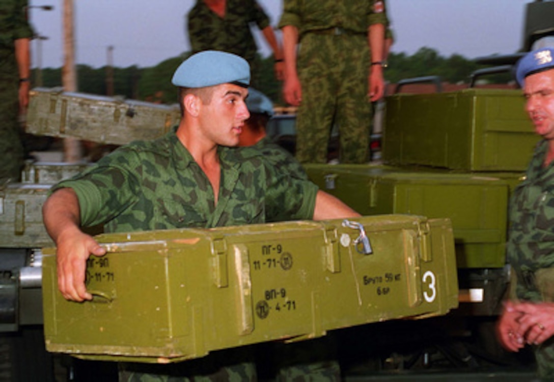 A Bulgarian soldier loads a box of weapons onto a bus at Marine Corps Air Station Cherry Point, N.C. on Aug. 12, 1996. The Bulgarian soldiers will be transported to Camp Lejeune, N.C., for Cooperative Osprey '96. Cooperative Osprey '96 is a NATO sponsored exercise as part of the alliance's Partnership for Peace program. The aim of the exercise is to develop interoperability among the participating forces through practice in combined peacekeeping and humanitarian operations. Three NATO countries and 16 Partnership for Peace nations are taking part in the field training exercise. 