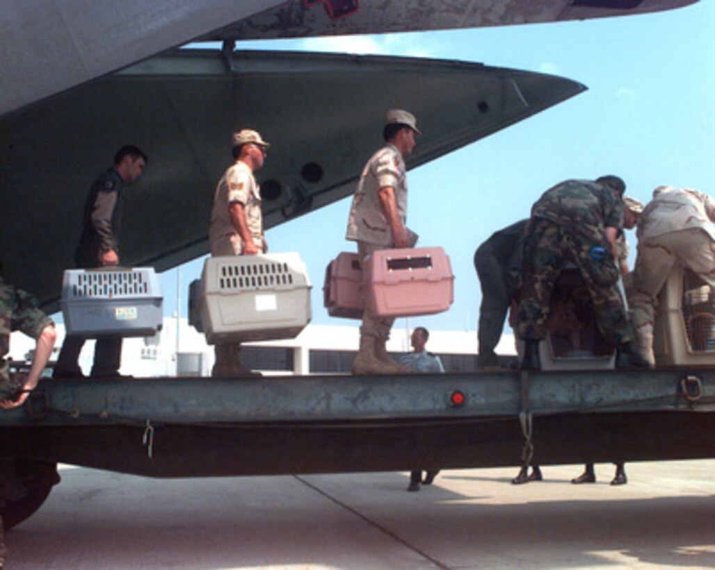 U. S. Air Force personnel off load a C-141 Starlifter carrying 90 pets evacuated from Saudi Arabia at Charleston Air Force Base, S.C., on Aug. 17, 1996. The pets belong to military and Department of Defense civilian employee families that are being relocated to the U.S. because of the terrorist threat in Saudi Arabia. Approximately 750 people are being evacuated. The animals were taken to an air conditioned holding facility where Air Force veterinarians inspected them and their owners picked them up. 