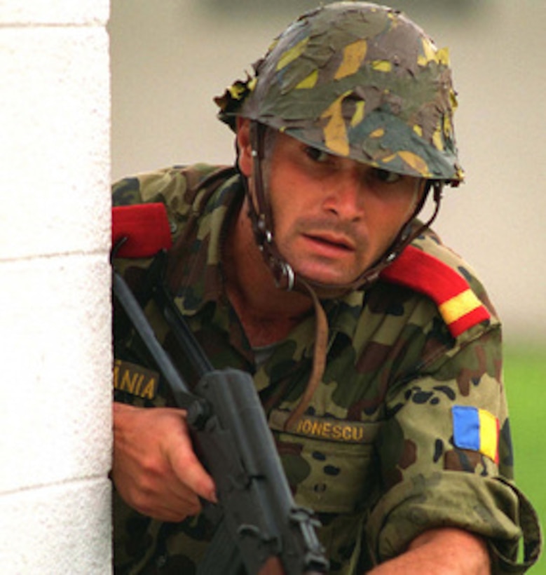 A Romanian soldier looks cautiously around the corner of a building during a Military Operations in Urban Terrain Situational Training Exercise at Camp Lejeune, N.C., on Aug. 17, 1996 as part of Cooperative Osprey '96. Cooperative Osprey '96 is a NATO sponsored exercise as part of the alliance's Partnership for Peace program. The aim of the exercise is to develop interoperability among the participating forces through practice in combined peacekeeping and humanitarian operations. Three NATO countries and 16 Partnership for Peace nations are taking part in the field training exercise. 