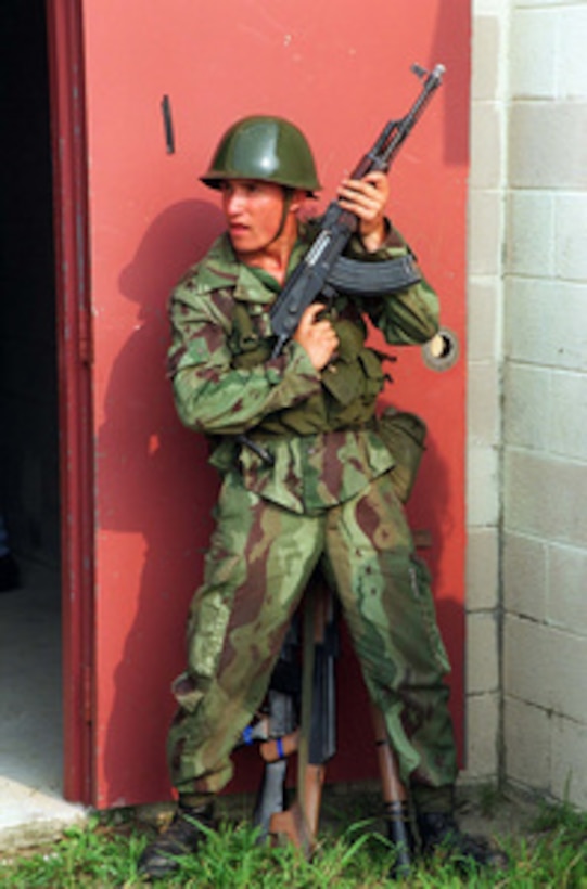 This Albanian soldier keeps an eye out for the 'enemy' during a Military Operations in Urban Terrain Situational Training Exercise at Camp Lejeune, N.C., on Aug. 17, 1996 as part of Cooperative Osprey '96. Cooperative Osprey '96 is a NATO sponsored exercise as part of the alliance's Partnership for Peace program. The aim of the exercise is to develop interoperability among the participating forces through practice in combined peacekeeping and humanitarian operations. Three NATO countries and 16 Partnership for Peace nations are taking part in the field training exercise. 