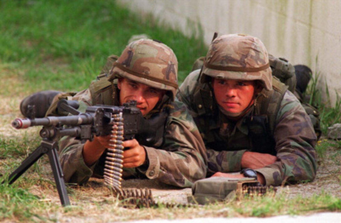 U.S. Marines sight in with an M-240G machine gun as they stand by to provide cover fire during a Military Operations in Urban Terrain Situational Training Exercise at Camp Lejeune, N.C., on Aug. 17, 1996 as part of Cooperative Osprey '96. Cooperative Osprey '96 is a NATO sponsored exercise as part of the alliance's Partnership for Peace program. The aim of the exercise is to develop interoperability among the participating forces through practice in combined peacekeeping and humanitarian operations. Three NATO countries and 16 Partnership for Peace nations are taking part in the field training exercise. The Marines are attached to the 2nd Battalion, 6th Marines. 