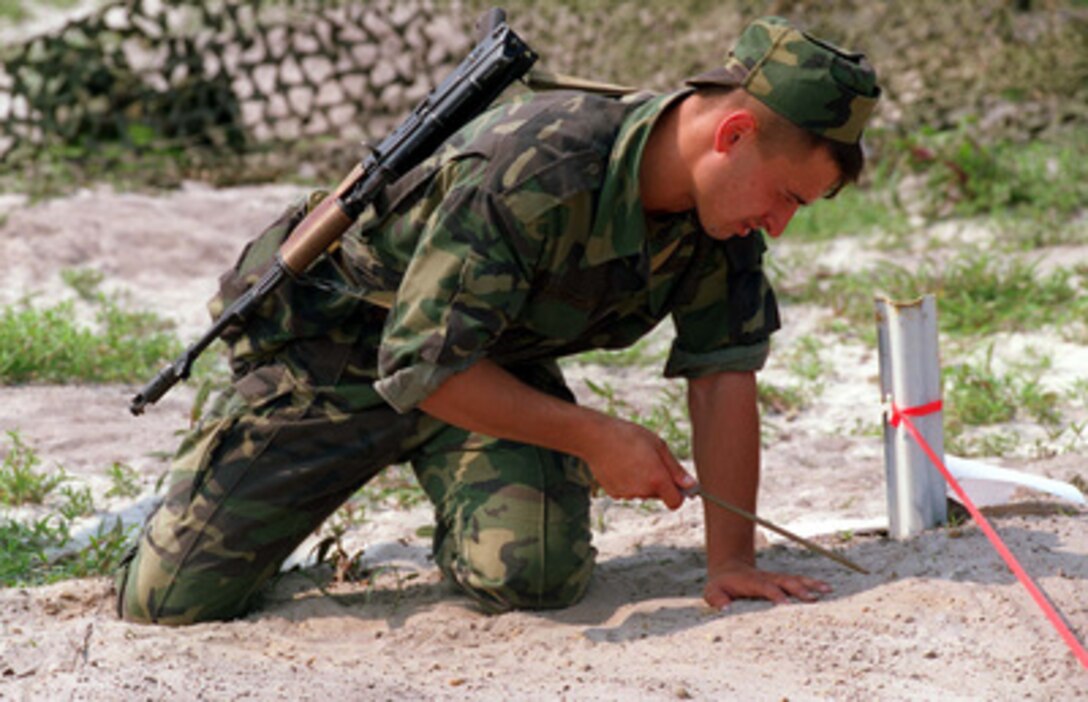A Moldovan soldier probes for mines, during the practical application phase of a Situational Training Exercise on Mine Awareness at Camp Lejeune, N.C., on Aug. 18, 1996, as part of Cooperative Osprey '96. Cooperative Osprey '96 is a NATO sponsored exercise as part of the alliance's Partnership for Peace program. The aim of the exercise is to develop interoperability among the participating forces through practice in combined peacekeeping and humanitarian operations. Three NATO countries and 16 Partnership for Peace nations are taking part in the field training exercise. 