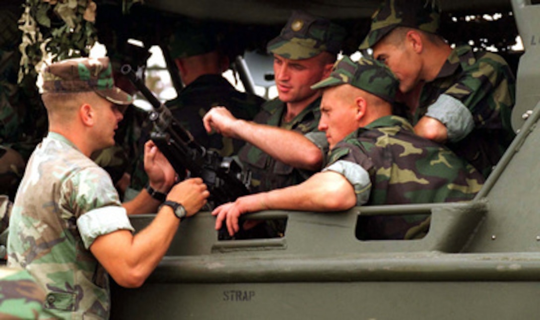 A U.S. Marine from Small Craft Company explains to troops from the Slovak Republic how a M240G machine gun mounted on a Riverine Assault Craft operates at Camp Lejeune, N.C., on Aug. 15, 1996. Small Craft Company Marines are familiarizing troops with riverine operations and transport by watercraft as part of Cooperative Osprey '96. Cooperative Osprey '96 is a NATO sponsored exercise as part of the alliance's Partnership for Peace program. The aim of the exercise is to develop interoperability among the participating forces through practice in combined peacekeeping and humanitarian operations. Three NATO countries and 16 Partnership for Peace nations are taking part in the field training exercise. Small Craft Company Marines are familiarizing troops with riverine operations and transport by watercraft. 