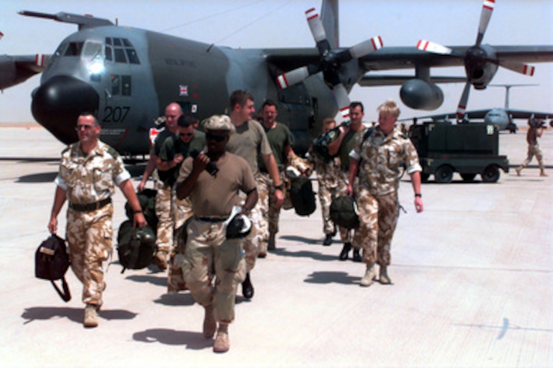 U.S. Air Force Staff Sgt. Darryl Martin, a Passenger Representative with the 615 Aerial Port Squadron, escorts British communications personnel from a British C-130 on the ramp to the receiving area at Prince Sultan Air Base, Al Kharj, Saudi Arabia, on Aug. 16, 1996. The communications team, deployed from Tactical Communications Wing, RAF Brize Norton, United Kingdom, will set up ground communications for British personnel that will soon be arriving to support the move of RAF Tornadoes conducting Operation Southern Watch to Al Kharj. Personnel, aircraft, and equipment are being moved from bases in Dhahran and Riyadh to the remote desert air base to reduce their vulnerability to terrorist attack. Southern Watch is the coalition enforcement of the no-fly-zone over Southern Iraq. Martin is deployed from Travis Air Force Base, Calif. 