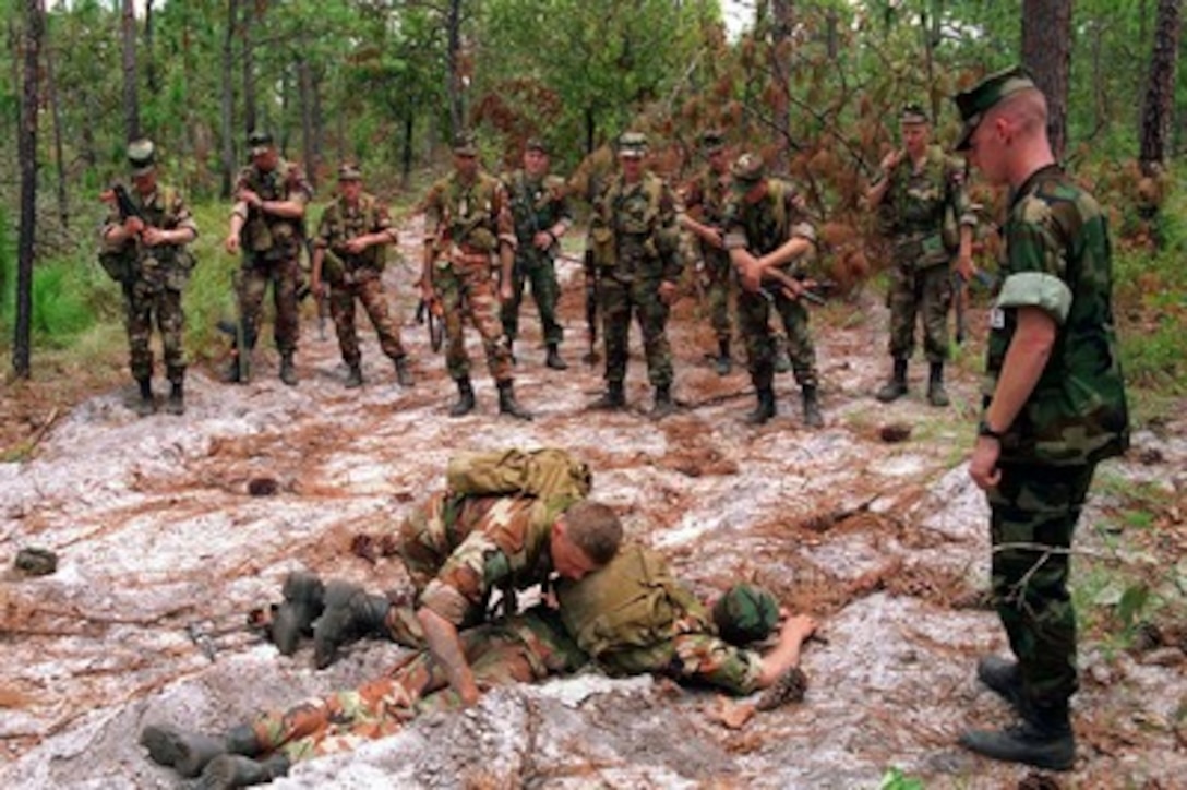 As his fellow soldiers watch, a member of the Baltic platoon, Company 6, practices recovery of personnel in a mine field during a Mine Awareness Situational Training Exercise at Camp Lejeune, N.C., on Aug. 16, 1996 as part of Cooperative Osprey '96. Cooperative Osprey '96 is a NATO sponsored exercise as part of the alliance's Partnership for Peace program. The aim of the exercise is to develop interoperability among the participating forces through practice in combined peacekeeping and humanitarian operations. Three NATO countries and 16 Partnership for Peace nations are taking part in the field training exercise. 