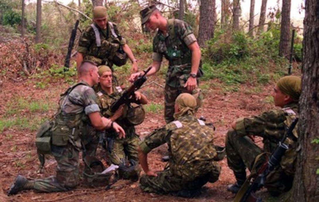Ukrainian Marines take advantage of a break in training to show their standard issue rifle to two U.S. Marines at Camp Lejeune, N.C., on Aug. 16, 1996, during Cooperative Osprey '96. Cooperative Osprey '96 is a NATO sponsored exercise as part of the alliance's Partnership for Peace program. The aim of the exercise is to develop interoperability among the participating forces through practice in combined peacekeeping and humanitarian operations. Three NATO countries and 16 Partnership for Peace nations are taking part in the field training exercise. 